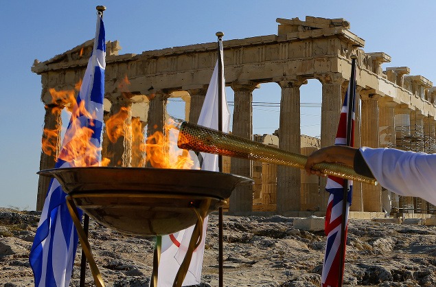 Grécky športovec zapaľuje olympijskú fakľu na vrchole aténskej Akropoly. Oheň bude plápolať na OH v Londýne.