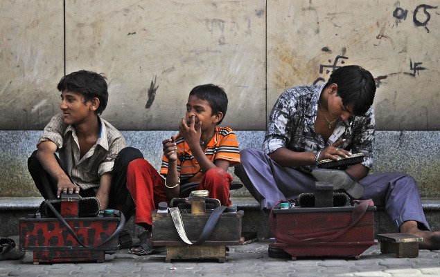 Indickí čističi topánok trávia celé dni na uliciach.