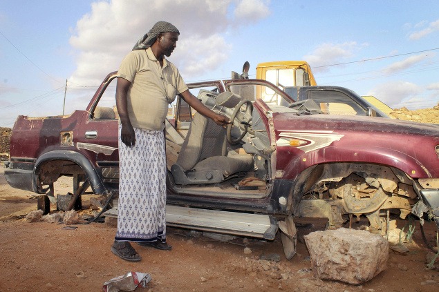 Mohamed Jama pri pozostatkoch svojho auta, ktoré bol nútený predať na súčiastky, aby mal na každodenné výdavky.