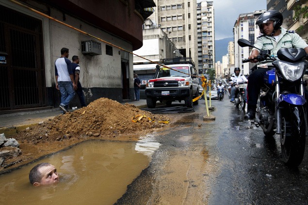 26. september: Robotník stojí až po krk vo vode počas opravy prasknutého potrubia vo venezuelskom Caracase.
