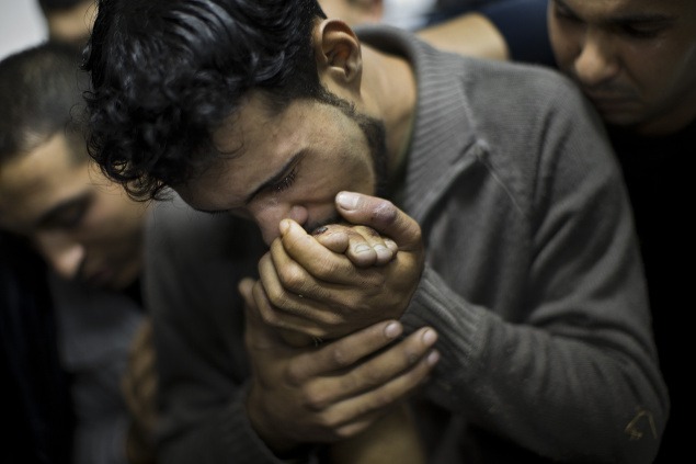 18. november: Palestínčan bozkáva ruku svojho mŕtveho príbuzného zabitého počas izraelského útoku na Gazu.
