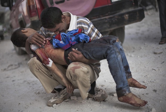 3. október: Plačúci otec drží v náručí telo svojho syna, ktorého zabila sýrska armáda neďaleko nemocnice v meste Aleppo.