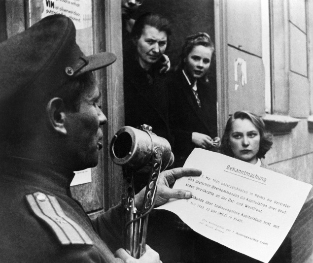 Sovietsky dôstojník číta v Berlíne text nemeckej kapitulácie.