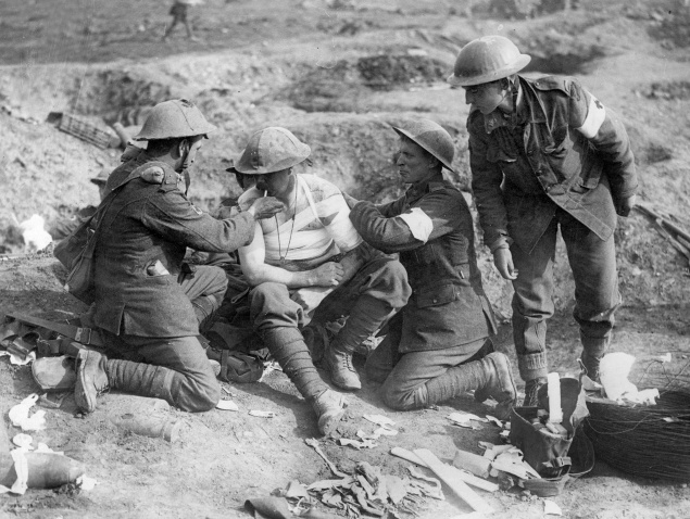 Kanaďania ošetrujú zraneného vojaka na bojom poli v septembri 1916.