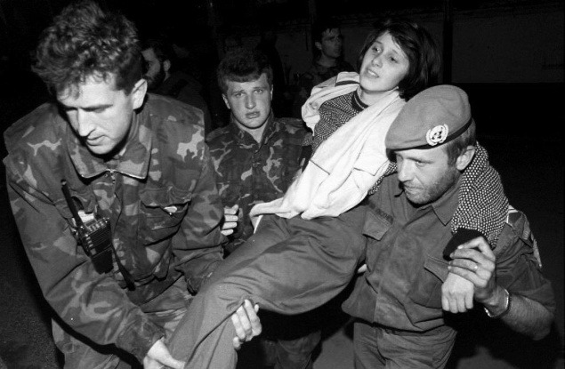 Bosnianski vojaci a vojak OSN odnášajú zranenú bosniansku ženu, ktorá bola evakuované zo Srebrenice do Tuzly.
