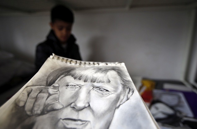 S portrétom nemeckej kancelárky Angely Merkelovej vo svojej izbe v utečeneckom tábore neďaleko Belehradu.
