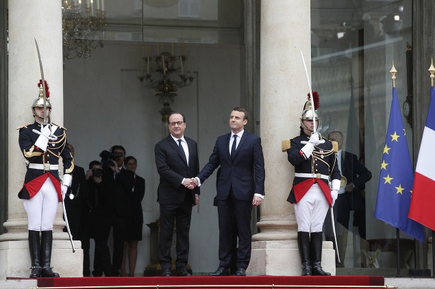 Odchádzajúci francúzsky prezident Francois Hollande (vľavo) a novozvolený francúzsky prezident Emmanuel MAcron sa zdravia pred začiatkom slávnostnej inaugurácie Emmanula Macrona v Elyzejskom paláci v Paríži.