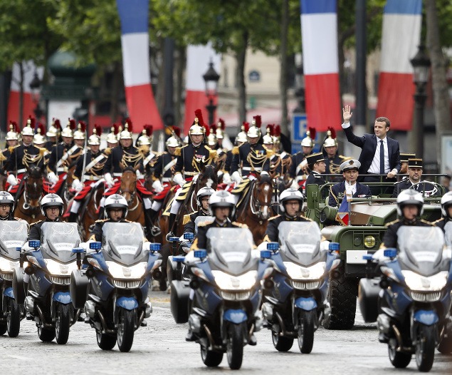 Nový francúzsky prezident máva davu ľudí na bulvári Champs- Élysées.