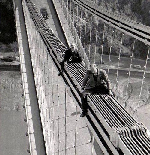 Charlie Thorne a Derek Phelps montujú svetlá na moste Clifton Suspension Bridge neďaleko anglického Bristolu