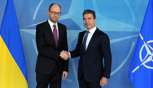 Ukrajinský premiér Arsenij Jaceňuk (vľavo) a generálny tajomník NATO Anders Fogh Rasmussen si podávajú ruky pred stretnutím v sídle NATO.