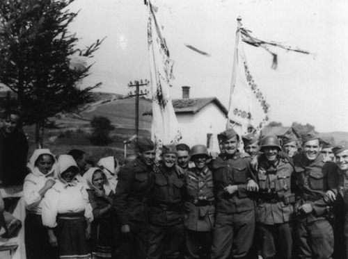 Nemeckí a slovenskí vojaci po jednom boku pózujú s obyvateľmi poľskej obce Komancza