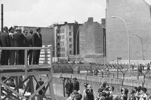 Americký prezident Kennedy sa z vyhliadkovej platformy pozerá na Berlínsky múr (jún 1963)