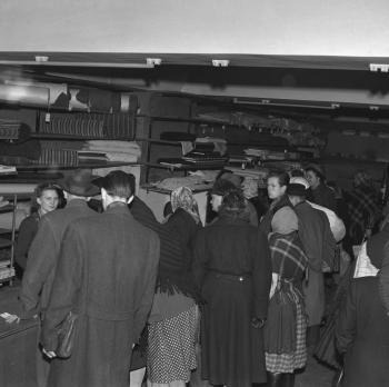 Pracujúci čakajú v rade v národnom podniku Vesna v Bratislave, kde sú plné regály kvalitného metrového tovaru počas vianočných trhov. (1950)