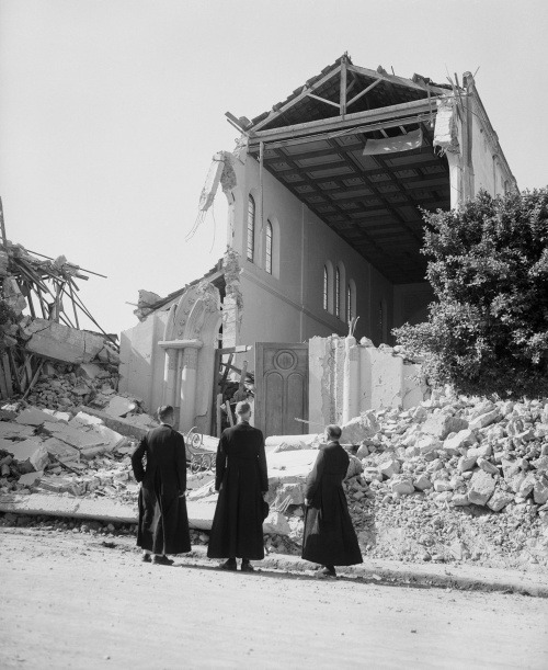 Kňazi pred zničeným kostolom.