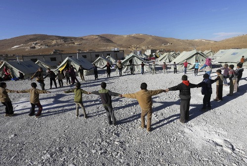 Fotografia sýrskych detí, ktoré sa hrajú mimo stanov v jednom z utečeneckých táborov na východe libanonskej hranice, pochádza z 29. novembra 2013. Väčšina zo sýrskych utečencov stále žije v okolí rodnej krajiny, najmä v Turecku, Jordánsku, Iraku a spomenutom Libanone.