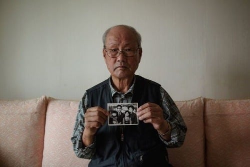 Park Jun-Dong (90) drží fotografiu svojho nebohého brata a jeho rodiny, ktorí zostali v Severnej Kórei