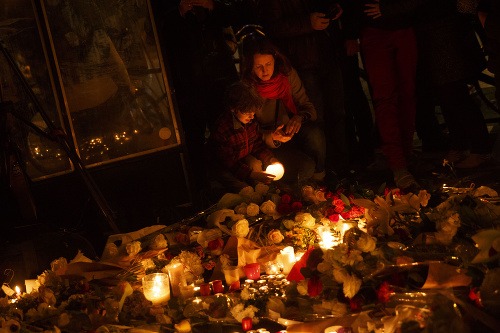 Sviečky a kvetky pred kaviarňou, v ktorej zahynulo 19 ľudí.