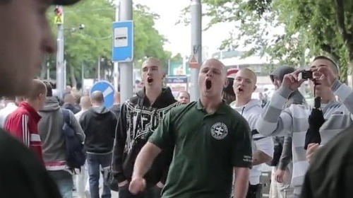 Mazurek (v zelenom tričku) vykrikuje na bratislavskej hlavnej stanici na moslimskú rodinu