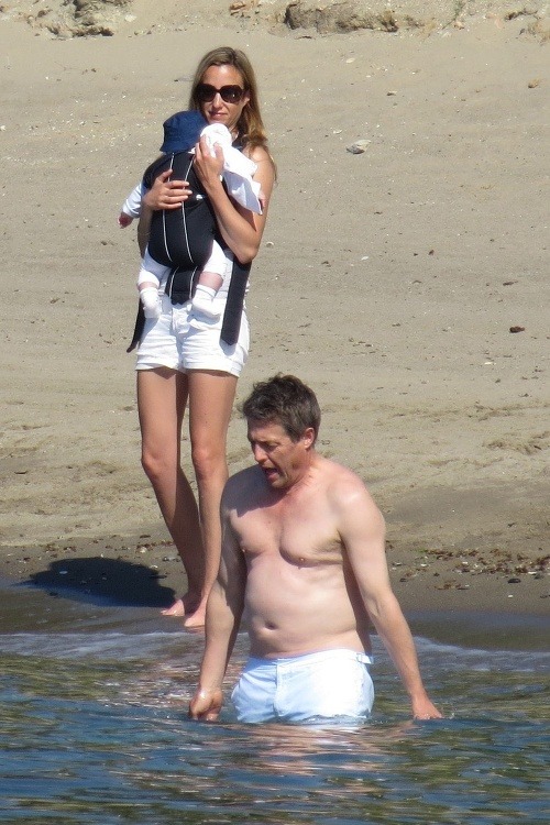 Hugh Grant si užíva dovolenku v spoločnosti matky svojich dvoch detí. Na pláži prekvapil pupkom a ovísajúcimi prsiami.