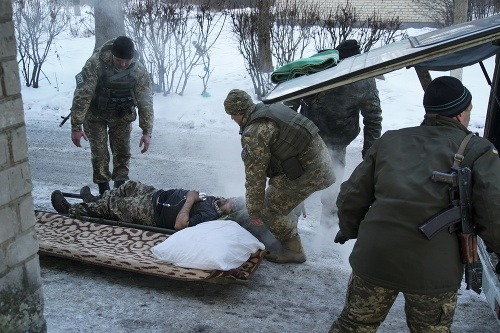 Ukrajinci odvážajú raneného z bojov
