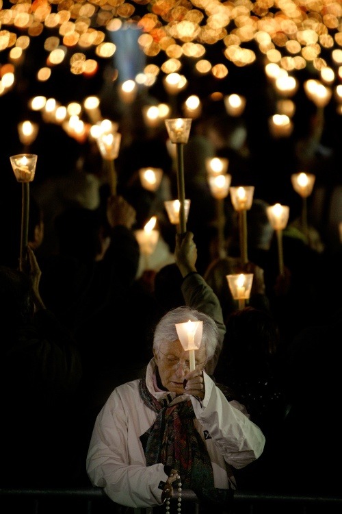 Veriacia drží sviečku počas sprievodu vo Fatime v strednom Portugalsku. 