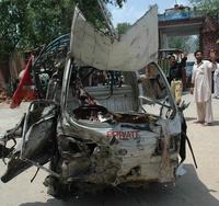 Obyvatelia pakistanského mesta Hangu stoja pri vraku auta, ktoré zničil výbuch bomby.