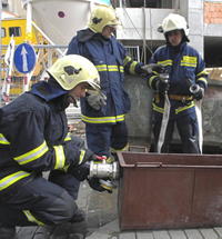 Hasiči pripravujú špeciálnu nádobu na ochladzovanie plynových fliaš.