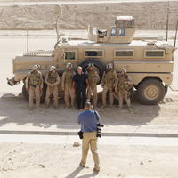 Prezident Bush (v čiernom) pózuje pre spoločnú fotku s vojakmi.