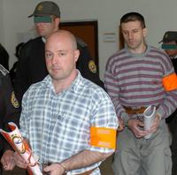 Členovia väzenskej a justičnej stráže vedú obžalovaných Petra G. (vľavo) a Stanislava Š., ktorí sú obvinení z vraždy 