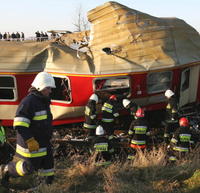 Hasiči skúmajú vrak vlaku po jeho zrážke s nákladným vozidlom 15. novembra 2007 neďaleko poľského Poledna, pri ktorej zahynuli 2 osoby.