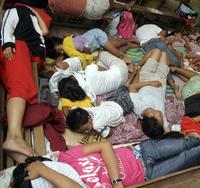  Ľudia evakuovaní pred tajfúnom spia v škole v Legaspi na východných Filipínach.
