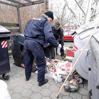 Policajti pri kontajneroch, kde bezdomovec našiel v kontajneri - v igelitke živého novorodenca.