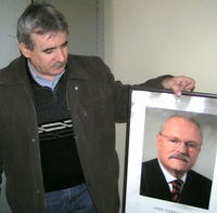 Starosta Ľubomír Varga ukazuje portrét prezidenta, ktorý takisto poškodil nedávny požiar.