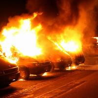 Horiace autá zapálené demonštrantmi v uliciach Kodane.
