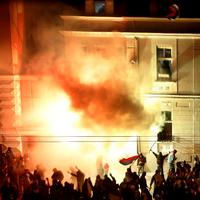 Demonštranti protestujúci proti nezávislosti Kosova zapaľujú budovu amerického veľvyslanectva.