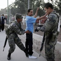 Vojaci prehľadávajú muža v meste Ciudad Juaréz