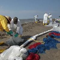 Robotníci čistia zvyšky ropy pozdĺž pláže v Port Fourchon
