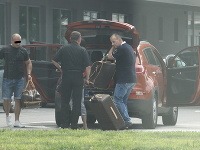 Borisa Kollára a mladú tmavovlásku priviezol na letisko šofér (vľavo). Batožinu im z auta pomáhal vykladať muž z letiska.