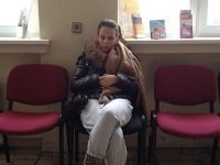 Tehotná Balúchová v gynekologickej ambulancii s rukami na brušku.