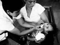 Magna zdravotná sestra očkuje dieťa proti detskej obrne v rámci mobilnej kliniky. NIKARAGUA.