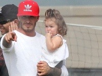 David Beckham poctivo vysvetľuje futbalové zákonitosti dcére Harper vo svojom náručí.