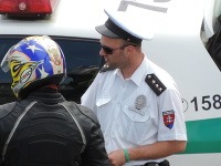 Policajt v družnom rozhovore s previnilým motorkárom. 
