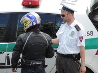 Policajt v družnom rozhovore s previnilým motorkárom. 