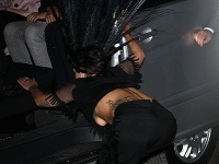 Lady Gaga bojuje s dlhokánskymi pávími perami na hlave pri nastupovaní do auta.