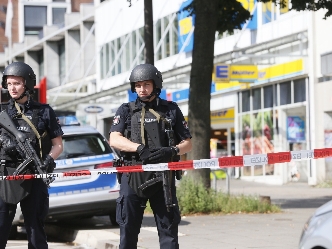 Policajti hliadkujú pred zatvoreným priestorom pred supermarketom v Hamburgu 28. júla 2017.