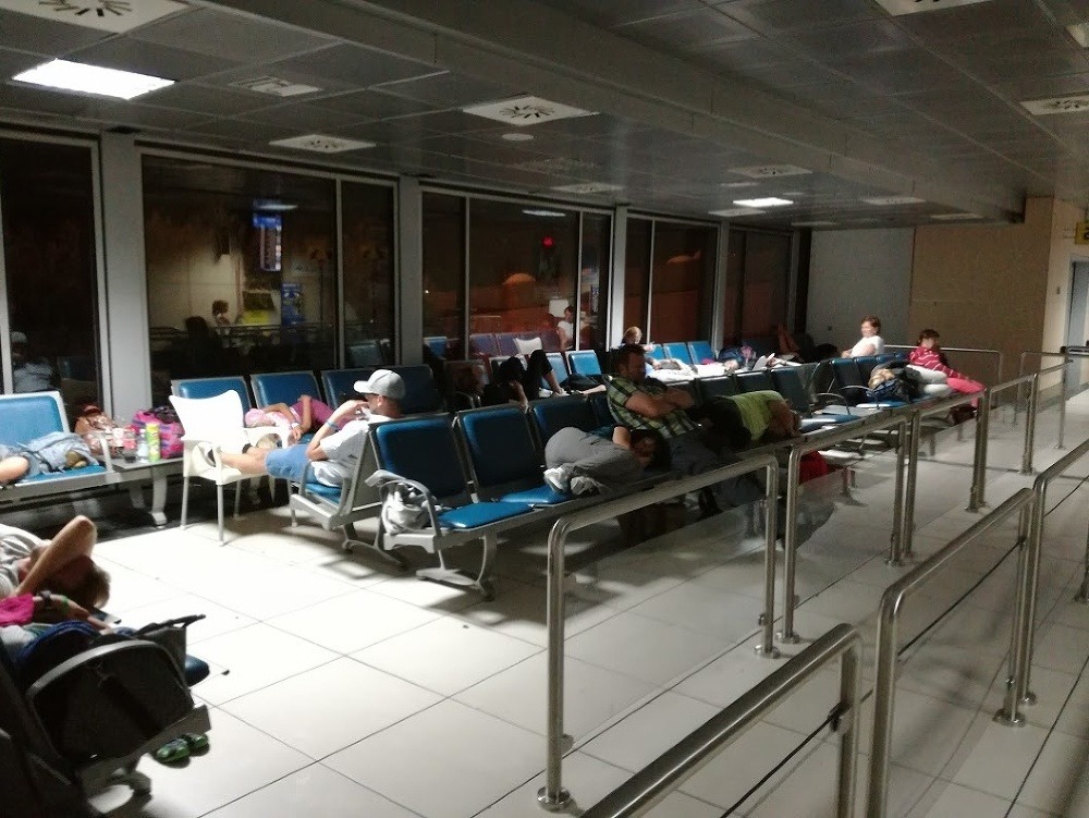 Cestujúci spali na sedadlách v letiskovej hale.