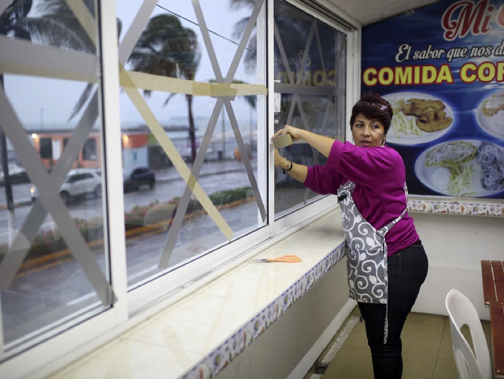 Na snímke žena zabezpečuje okná reštaurácie pred príchodom búrky Franklin v mexickom meste Veracruz