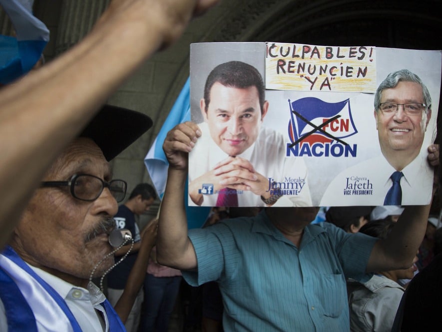 Muž s transparentom počas protestu proti prezidentovi Moralesovi.