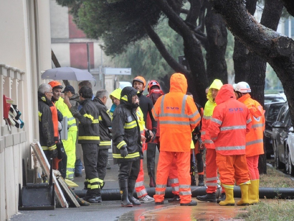 Na snímke záchranári a hasiči pracujú na mieste, kde prišli o život piati ľudia po záplavách v talianskom meste Livorno.