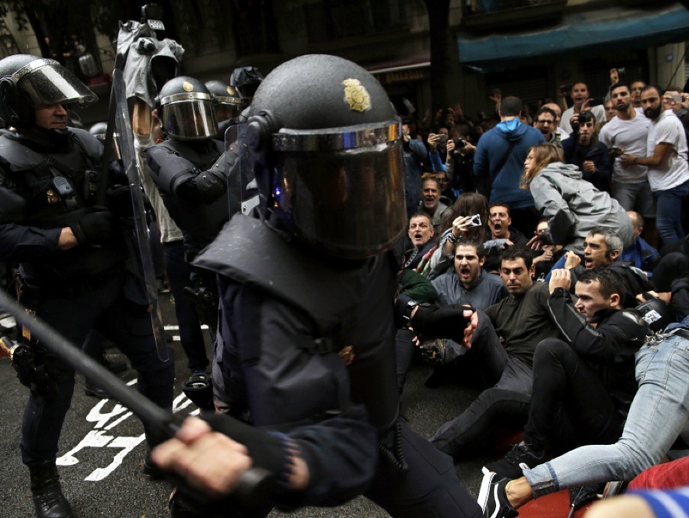 Policajt v akcii počas katalánskeho referenda.